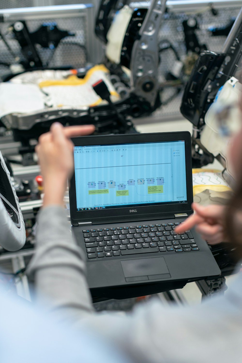 Una ingeniera revisando datos en una computadora junto a equipos
