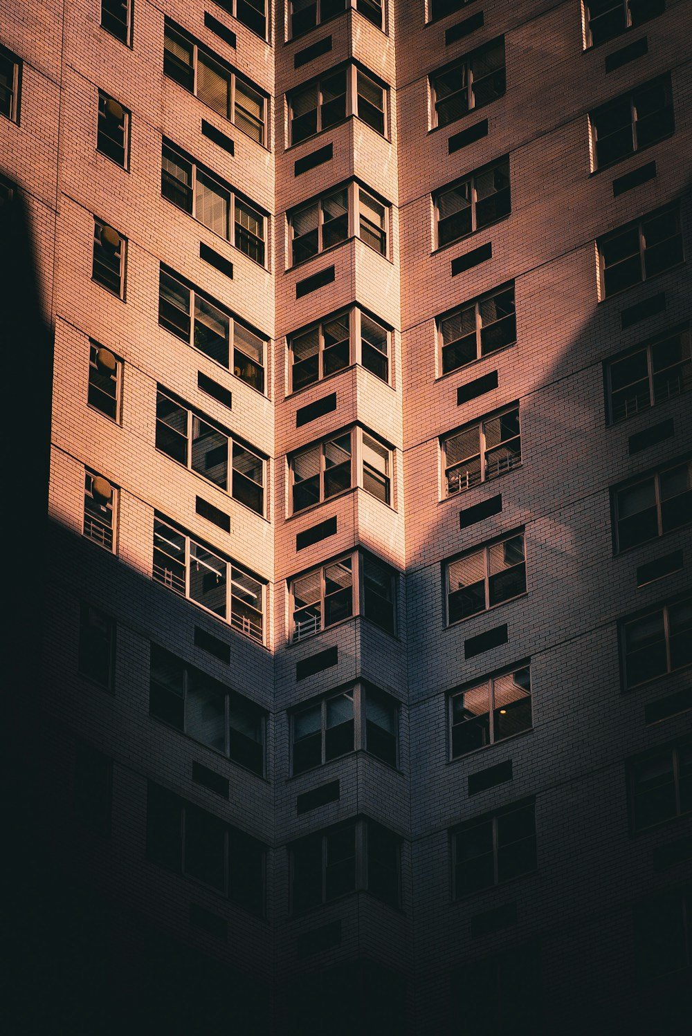 Luz sobre la fachada de ladrillo de un edificio de departamentos